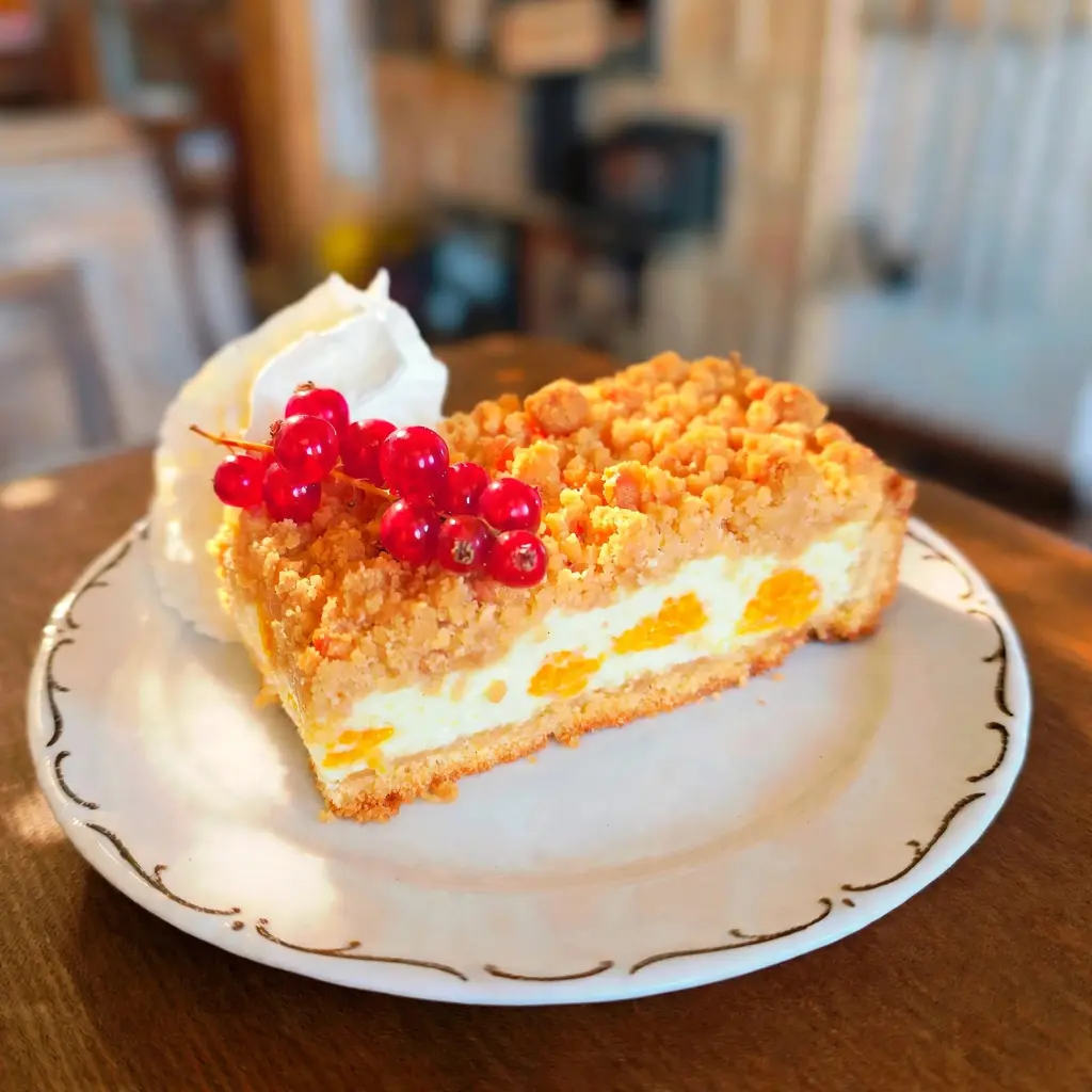 Kuchen Nahaufnahme Frisches Stück fruchtiger Mandarinen-Schmandkuchen mit Glanzspiegel, garniert mit Johannisbeeren und Sahne